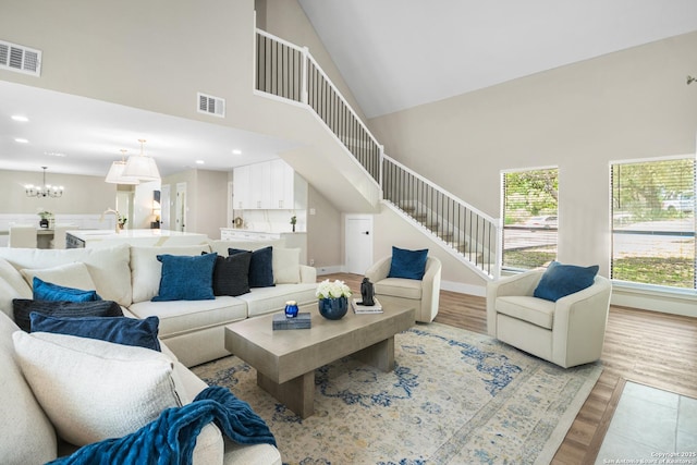 29302 Grand Coteau, Boerne, TX 78015 - living room featuring light wood finished floors, a high ceiling, stairway, a chandelier, and recessed lighting