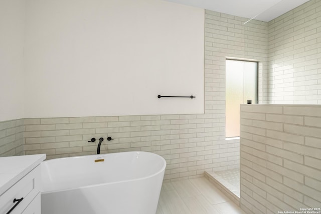 29302 Grand Coteau, Boerne, TX 78015 - full bathroom with tile walls, walk in shower, a freestanding bath, vanity, and tile patterned flooring
