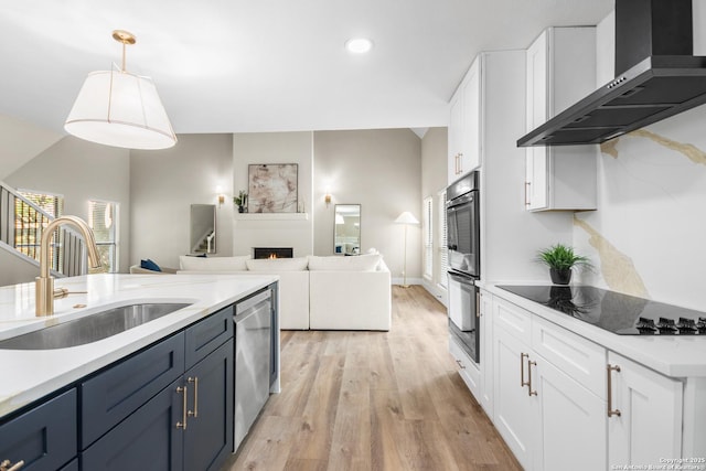 29302 Grand Coteau, Boerne, TX 78015 - kitchen with wall chimney exhaust hood, a sink, appliances with stainless steel finishes, light wood-style flooring, and light countertops