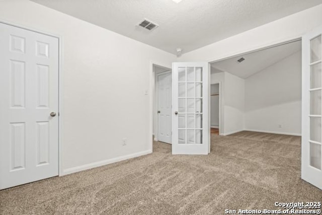 3823 Southern Sky, San Antonio, TX 78222 - unfurnished bedroom featuring carpet flooring, french doors, baseboards, and vaulted ceiling