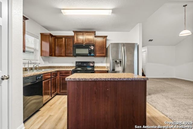 3823 Southern Sky, San Antonio, TX 78222 - kitchen with black appliances, a sink, a kitchen island, decorative light fixtures, and light wood-style flooring