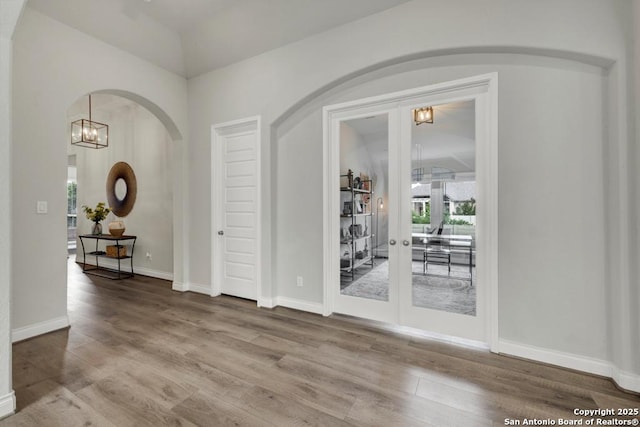 562 Orchard Way, New Braunfels, TX 78132 - spare room with arched walkways, vaulted ceiling, wood finished floors, french doors, and baseboards