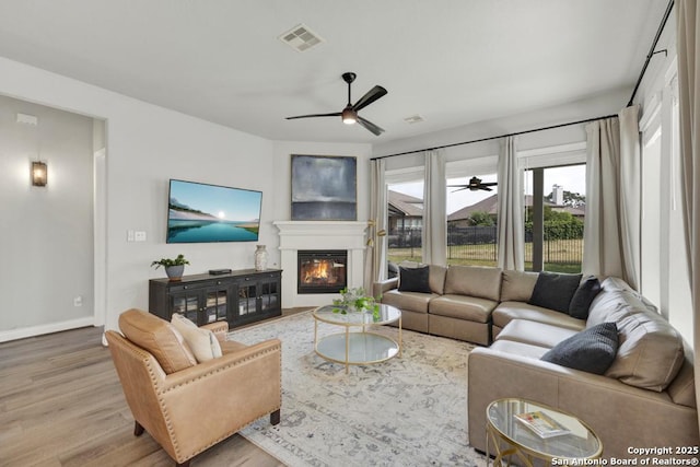 562 Orchard Way, New Braunfels, TX 78132 - living room with ceiling fan, wood finished floors, a glass covered fireplace, and baseboards