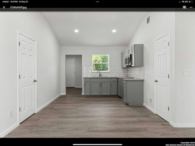 1711 Hermine, San Antonio, TX 78201 - kitchen with gray cabinetry, vaulted ceiling, a sink, light wood-style floors, and recessed lighting