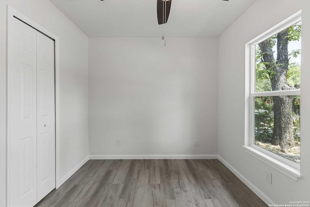 1711 Hermine, San Antonio, TX 78201 - unfurnished bedroom with wood finished floors, baseboards, a closet, and a ceiling fan