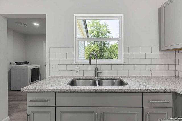 1711 Hermine, San Antonio, TX 78201 - kitchen with washer / dryer, a sink, gray cabinets, and decorative backsplash