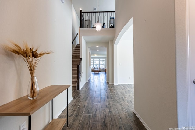 7421 Cimarron Lk, Boerne, TX 78015 - corridor featuring arched walkways, a high ceiling, dark wood-style flooring, and baseboards