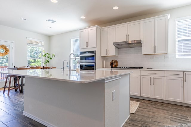 7421 Cimarron Lk, Boerne, TX 78015 - kitchen with under cabinet range hood, a sink, double oven, backsplash, and recessed lighting