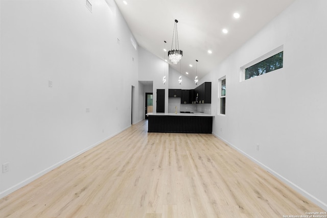 1422 Sherman, San Antonio, TX 78202 - unfurnished living room featuring recessed lighting, light wood-style flooring, high vaulted ceiling, a chandelier, and baseboards