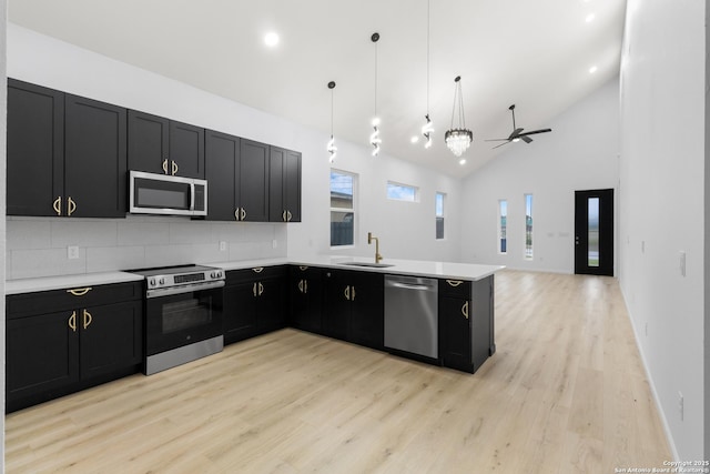 1422 Sherman, San Antonio, TX 78202 - kitchen featuring stainless steel appliances, dark cabinetry, a ceiling fan, a peninsula, and light wood finished floors