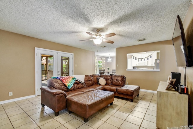 9311 Bowen Dr, San Antonio, TX 78250 - living room featuring french doors, light tile patterned floors, ceiling fan, baseboards, and a textured ceiling