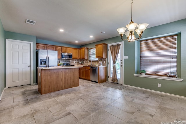 12707 Avens Arbor, San Antonio, TX 78253 - kitchen with stainless steel appliances, a chandelier, light countertops, baseboards, and tasteful backsplash
