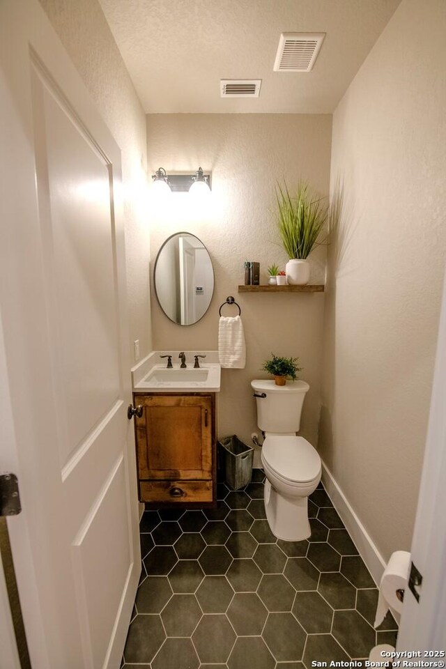 113 Bayberry Ct, La Vernia, TX 78121 - half bathroom featuring vanity, toilet, and tile patterned flooring