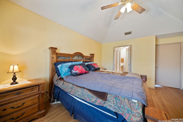 11334 Bald Mountain Dr, San Antonio, TX 78245 - bedroom featuring light wood-style floors, a textured ceiling, lofted ceiling, a ceiling fan, and ensuite bathroom