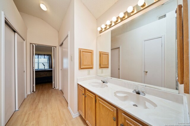 11334 Bald Mountain Dr, San Antonio, TX 78245 - full bathroom with double vanity, wood finished floors, lofted ceiling, and connected bathroom