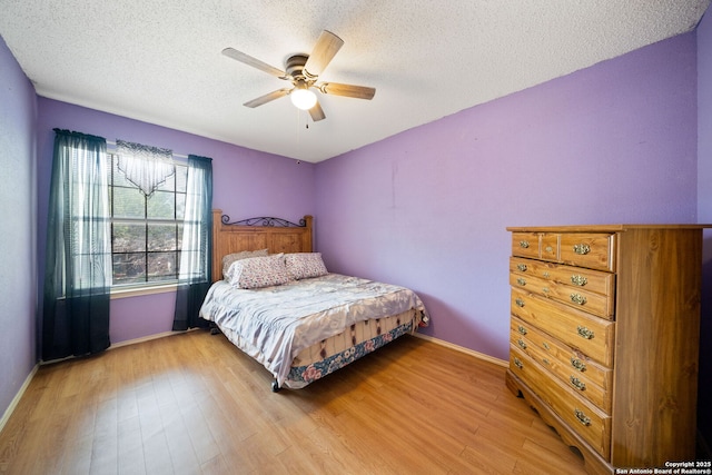 11334 Bald Mountain Dr, San Antonio, TX 78245 - bedroom with a textured ceiling, light wood finished floors, baseboards, and ceiling fan