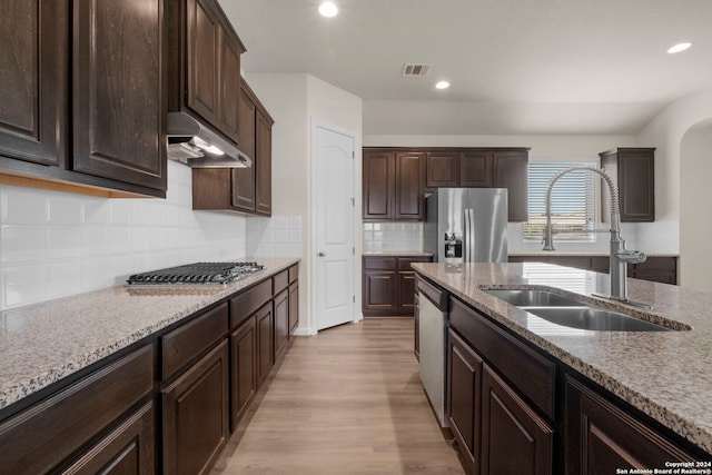 6595 Mason Vly, Schertz, TX 78108 - kitchen featuring a sink, under cabinet range hood, stainless steel appliances, light wood-style flooring, and dark brown cabinetry