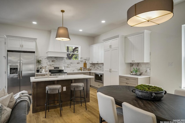 1947 W French Pl, San Antonio, TX 78201 - kitchen featuring stainless steel appliances, custom range hood, a sink, light wood finished floors, and recessed lighting