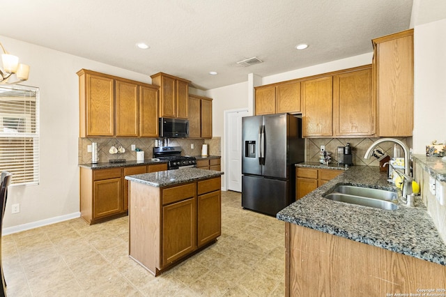8607 Lahemaa, San Antonio, TX 78251 - kitchen featuring stainless steel appliances, a sink, a center island, dark stone counters, and brown cabinetry