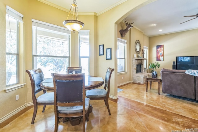 448 Western, Bandera, TX 78003 - dining space with ornamental molding, baseboards, tile patterned floors, a ceiling fan, and a stone fireplace