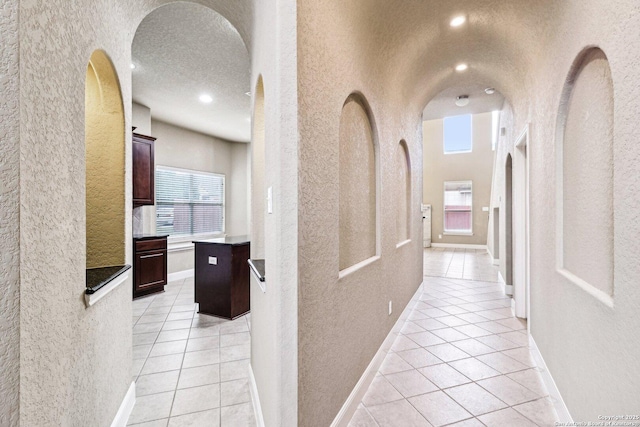 5514 Waldon Walk, San Antonio, TX 78261 - corridor featuring light tile patterned floors, a textured wall, arched walkways, and baseboards