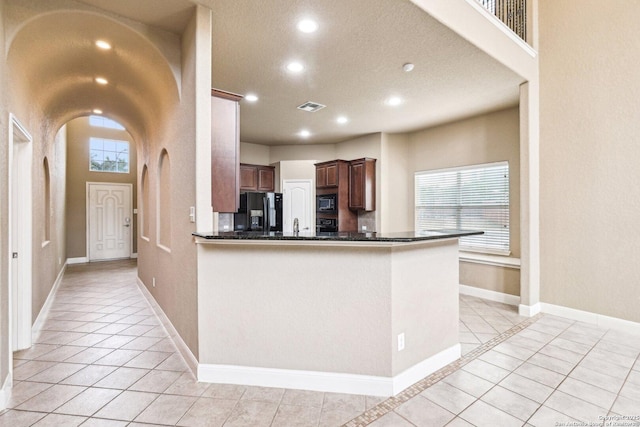 5514 Waldon Walk, San Antonio, TX 78261 - kitchen featuring black fridge, light tile patterned floors, built in microwave, recessed lighting, and baseboards