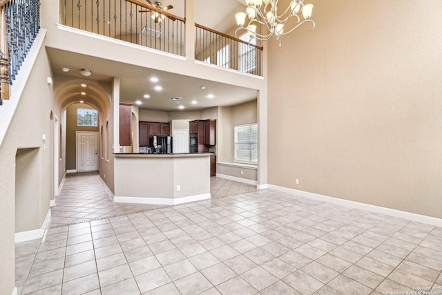 5514 Waldon Walk, San Antonio, TX 78261 - unfurnished living room with light tile patterned floors, healthy amount of natural light, a chandelier, a high ceiling, and baseboards