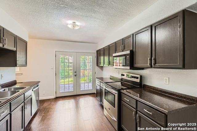 6862 Maple Spgs Unit 6862, San Antonio, TX 78249 - kitchen with stainless steel appliances, french doors, dark countertops, dark wood-type flooring, and a textured ceiling