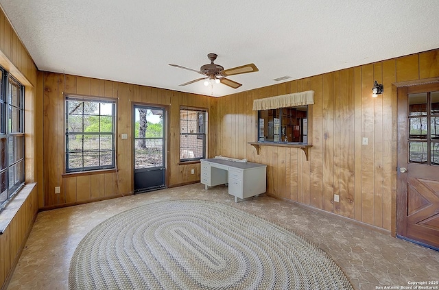 1212 County Road 337, La Vernia, TX 78121 - foyer entrance with wooden walls, a textured ceiling, baseboards, a ceiling fan, and built in study area
