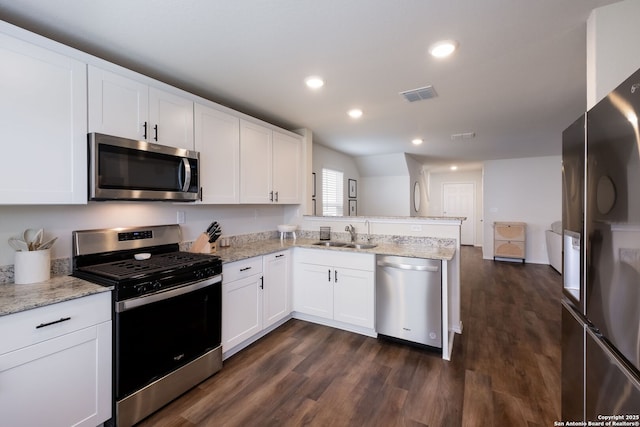 13735 Prospector Post, San Antonio, TX 78253 - kitchen with stainless steel appliances, a peninsula, a sink, dark wood finished floors, and white cabinetry