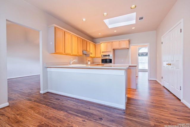 5535 Circle Oak Dr, Bulverde, TX 78163 - kitchen with oven, a skylight, light brown cabinets, under cabinet range hood, and recessed lighting