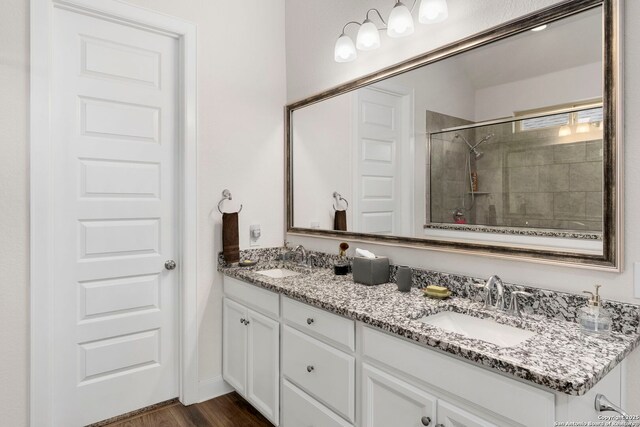 243 Bamberger, New Braunfels, TX 78132 - bathroom featuring double vanity, a tile shower, and wood finished floors