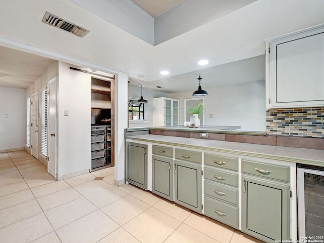 19914 Encino Moss, San Antonio, TX 78259 - kitchen with beverage cooler, light tile patterned flooring, hanging light fixtures, decorative backsplash, and green cabinetry