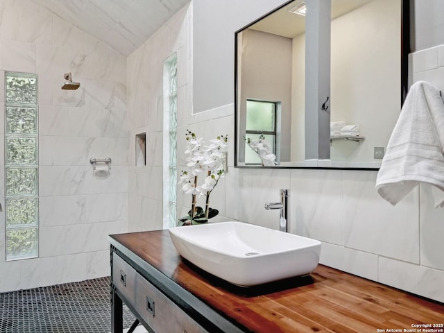 19914 Encino Moss, San Antonio, TX 78259 - full bathroom featuring a walk in shower, vanity, lofted ceiling, and tile walls