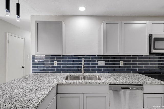 7311 Lansbury Dr, San Antonio, TX 78250 - kitchen featuring stainless steel appliances, a sink, decorative backsplash, light stone counters, and recessed lighting