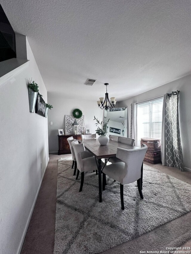 510 Tres Caminos, San Antonio, TX 78245 - carpeted dining space featuring a chandelier, a textured ceiling, and baseboards