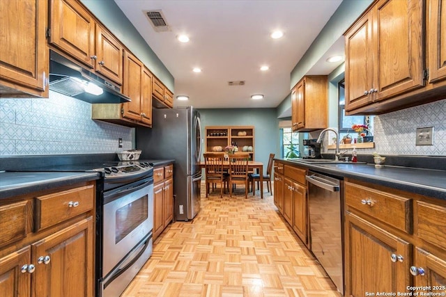 4415 Shavano Way, San Antonio, TX 78249 - kitchen featuring stainless steel appliances, a sink, under cabinet range hood, dark countertops, and brown cabinets