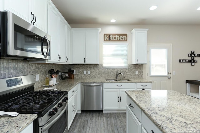 927 Lambshead Draw, San Antonio, TX 78245 - kitchen with appliances with stainless steel finishes, a sink, tasteful backsplash, white cabinetry, and recessed lighting