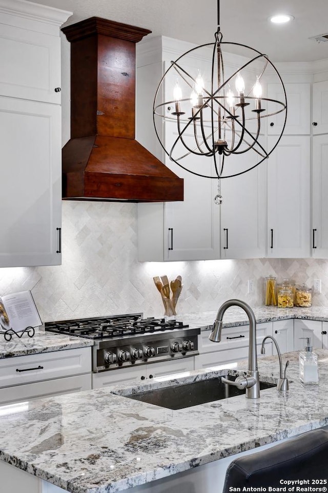 11 Gemsbuck Rise, San Antonio, TX 78258 - kitchen featuring custom exhaust hood, a sink, white cabinetry, light stone countertops, and recessed lighting