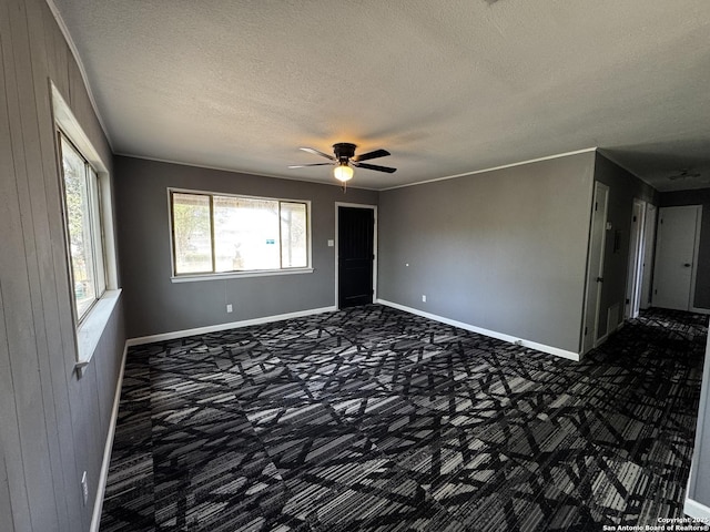 19518 Florence, Lytle, TX 78052 - empty room featuring carpet flooring, a textured ceiling, a ceiling fan, baseboards, and wood walls