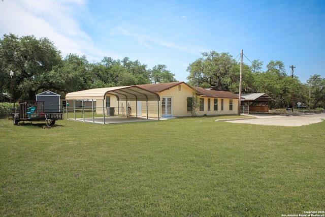 102 Southgate, Pleasanton, TX 78064 - rear view of property with a detached carport, driveway, stucco siding, and french doors