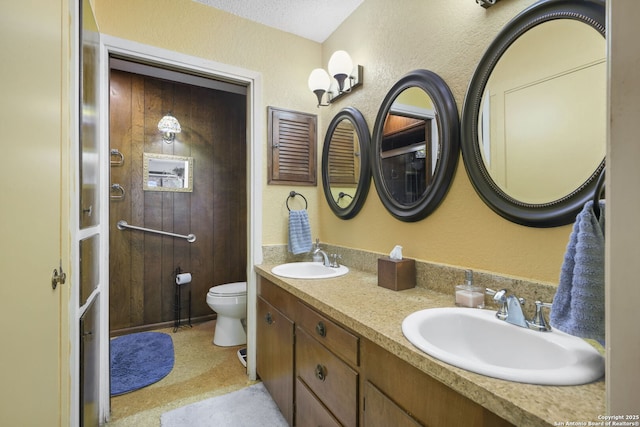 102 Southgate, Pleasanton, TX 78064 - full bathroom featuring double vanity, toilet, and a textured wall