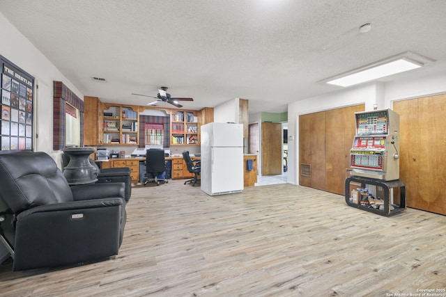 102 Southgate, Pleasanton, TX 78064 - living area with a textured ceiling, an office area, light wood-style floors, and a ceiling fan