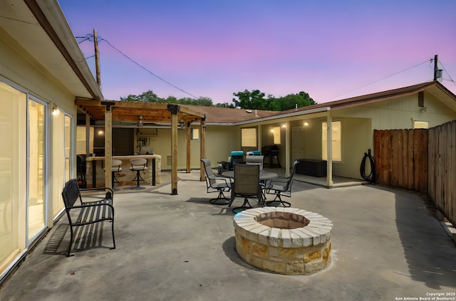 102 Southgate, Pleasanton, TX 78064 - patio terrace at dusk featuring a fire pit, a patio area, outdoor dining area, and grilling area