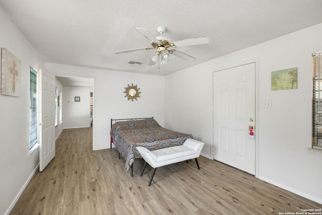 102 Southgate, Pleasanton, TX 78064 - bedroom featuring light wood finished floors, baseboards, a textured ceiling, and ceiling fan