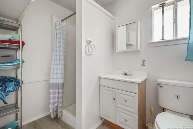 102 Southgate, Pleasanton, TX 78064 - full bathroom featuring vanity, toilet, a shower with shower curtain, and wood finished floors
