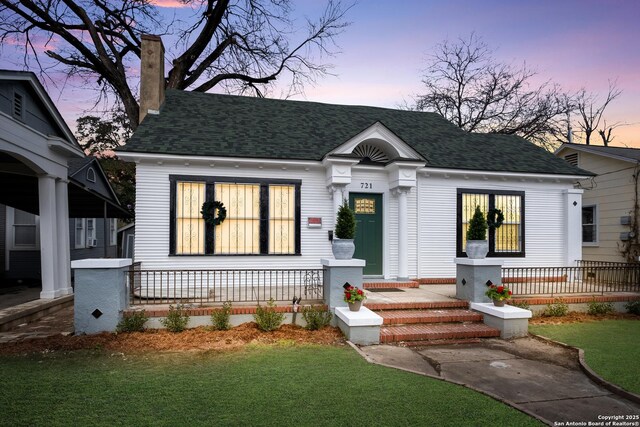 721 W Kings Hwy, San Antonio, TX 78212 - view of front of house featuring a porch, roof with shingles, a front lawn, and a chimney