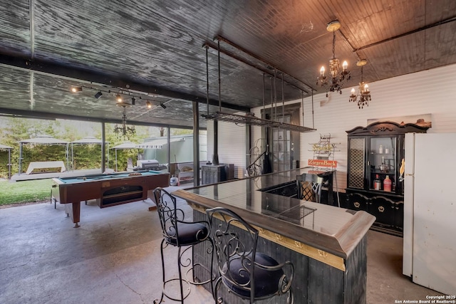 721 W Kings Hwy, San Antonio, TX 78212 - bar area featuring freestanding refrigerator, finished concrete flooring, billiards table, a chandelier, and a wood stove