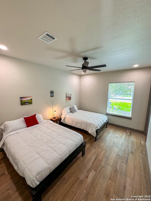 34 Lazy Day, Concan, TX 78838 - bedroom with wood finished floors, a ceiling fan, a textured ceiling, and recessed lighting