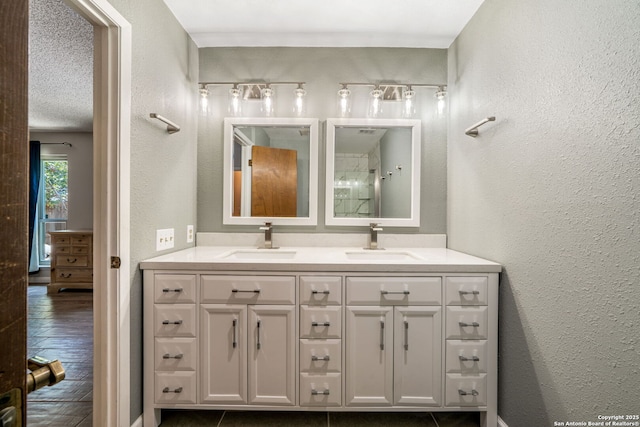 2102 Oak Wild St, San Antonio, TX 78232 - full bathroom featuring double vanity, a textured wall, and wood finished floors